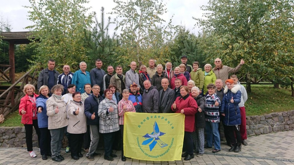 Confederation members posing with their flag outdoors